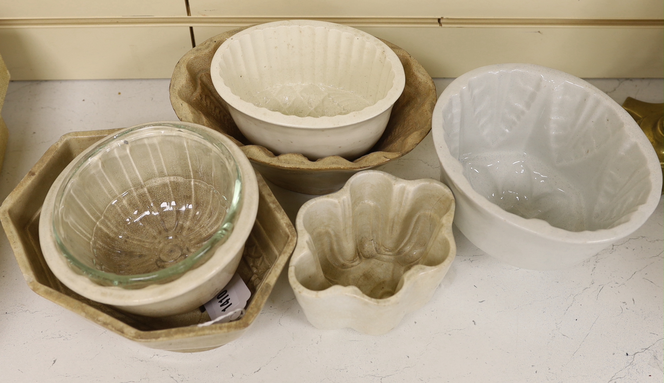 Six ceramic and a glass jelly mould, (7) largest 22cm wide